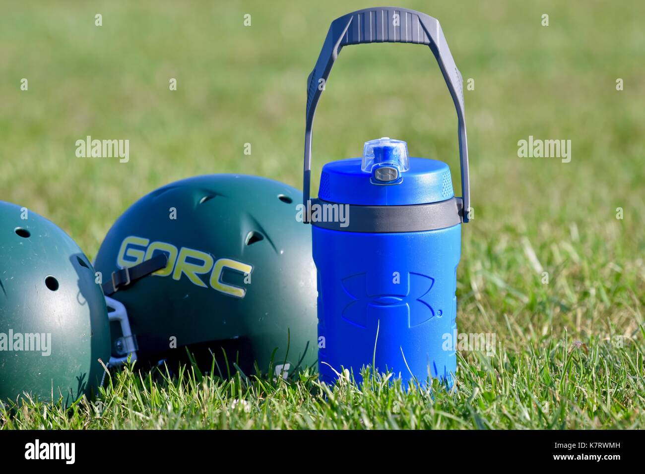 Sotto la corazza di acqua in bottiglia accanto al casco da football al gioco di sport Foto Stock