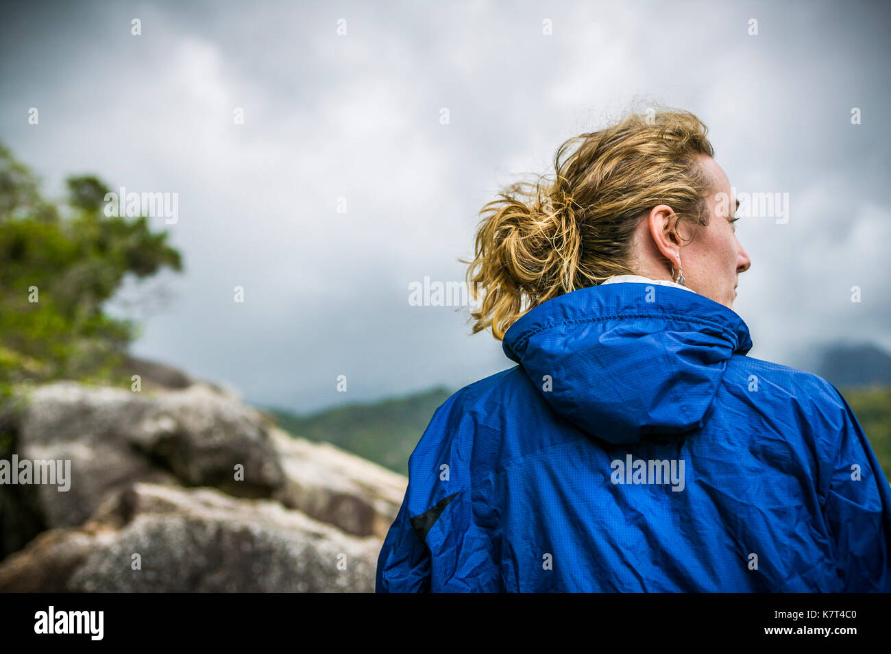 Una donna vista da dietro che indossa una giacca pioggia come minaccioso meteo approcci. Monsson stagione in Thailandia, Ao Thong Nai Pan Noi, Koh Phangan / Ko P Foto Stock