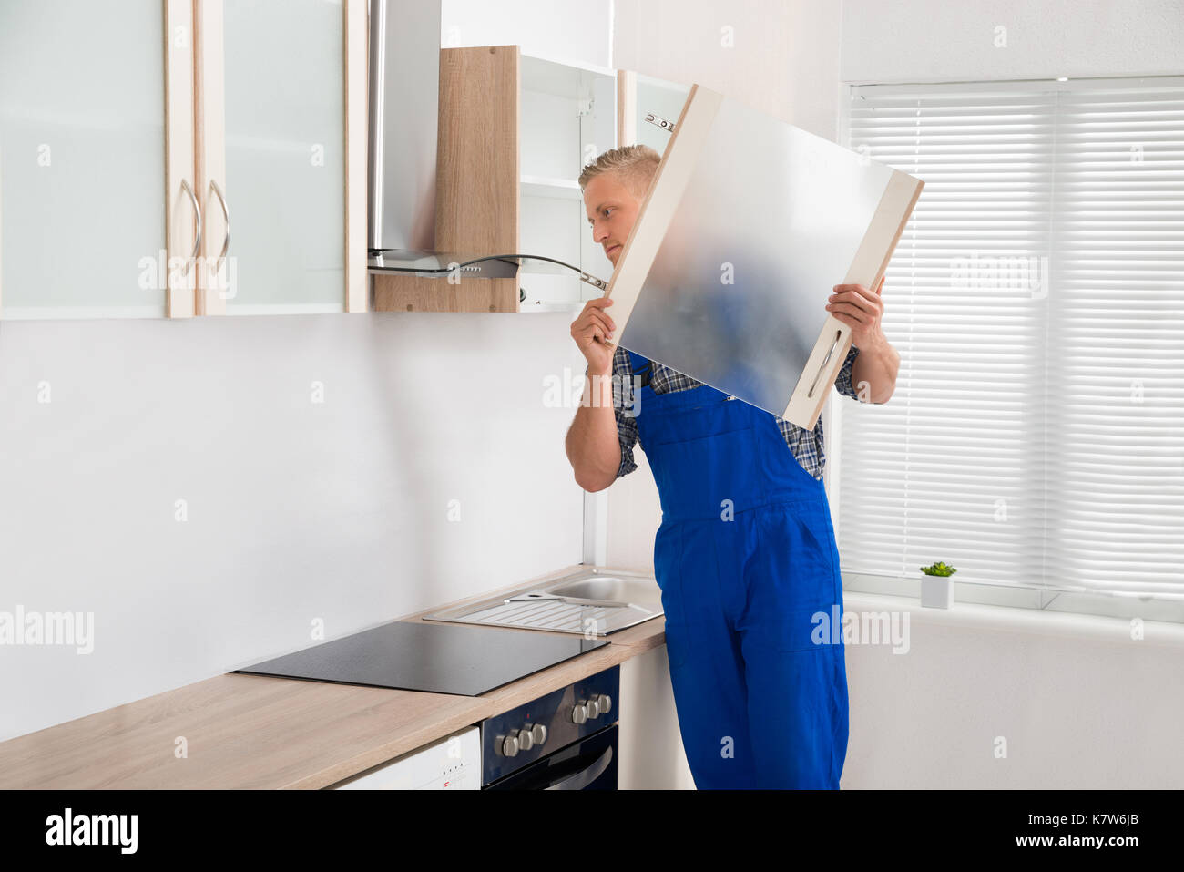 Giovane maschio falegname mobili in camera con cucina Foto Stock