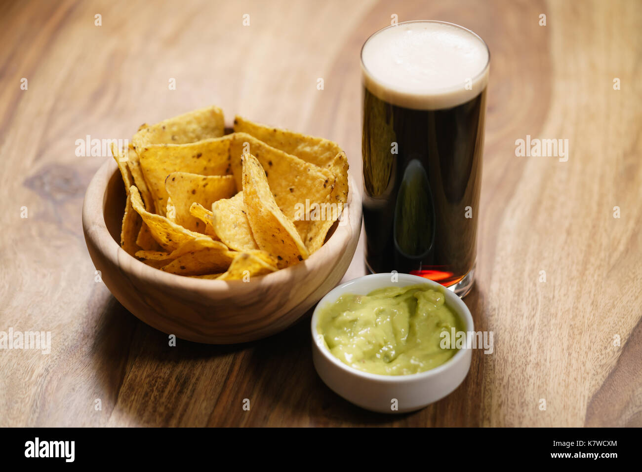 Birra scura con nachos e salsa guacamole Foto Stock