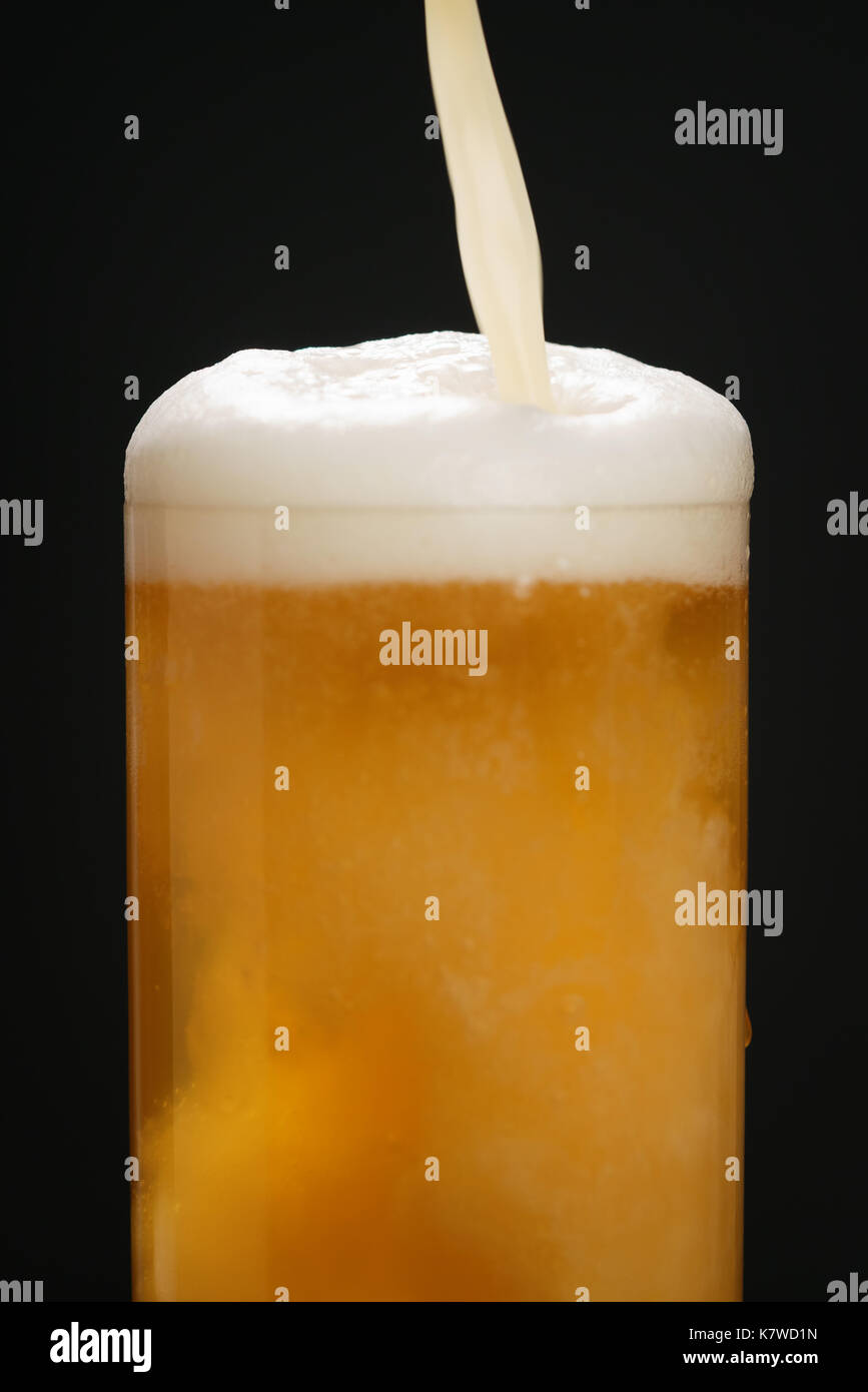 Grano di birra non filtrata versata in vetro sopra lo sfondo scuro Foto Stock