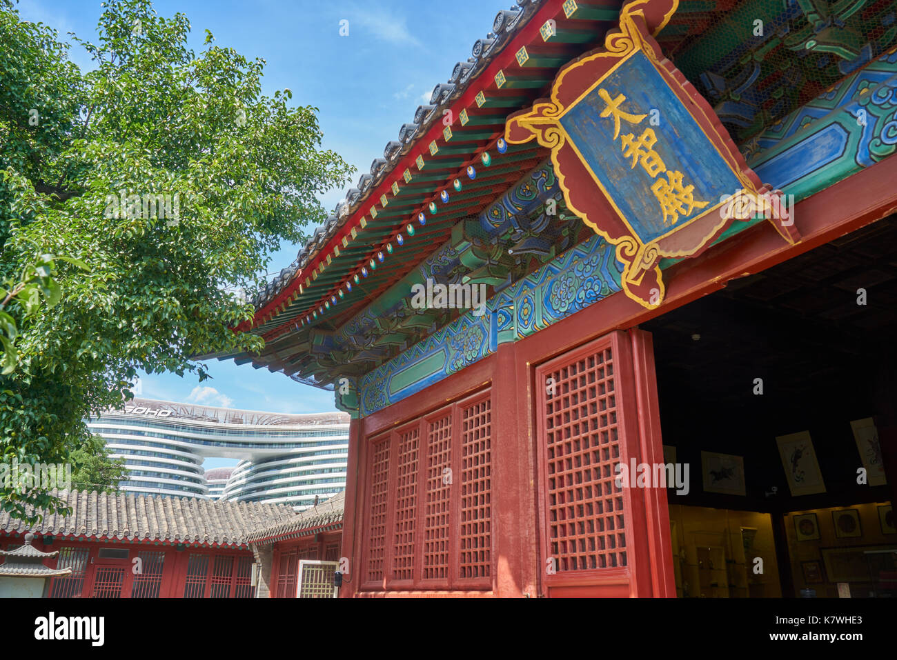 La sala principale del tempio Zhihua a Pechino in Cina. In contrasto con lo sfondo della bianca architettura moderna Chaowai Soho Foto Stock