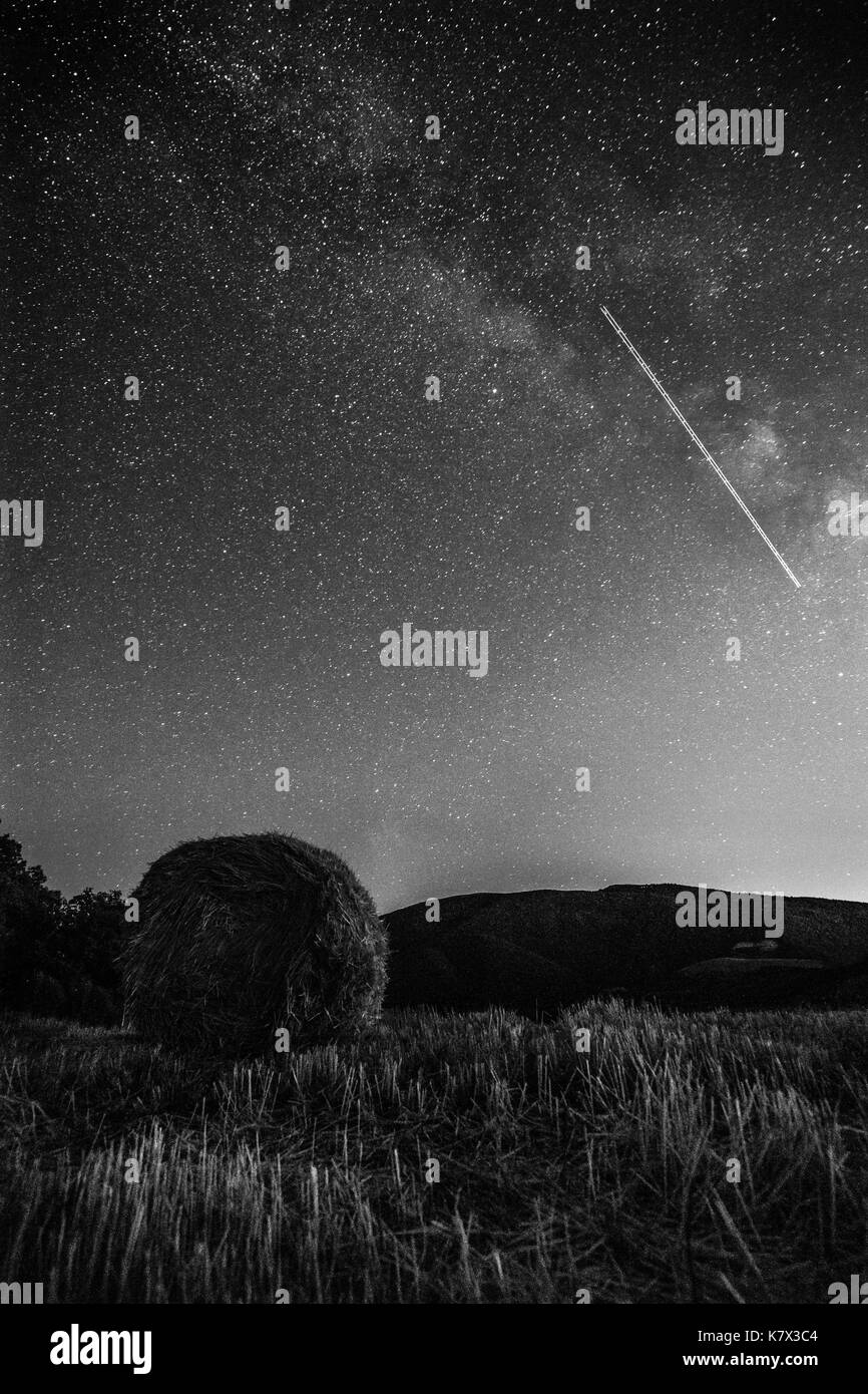 Bellissima vista del cielo notturno e la via lattea su un prato con balle di fieno Foto Stock