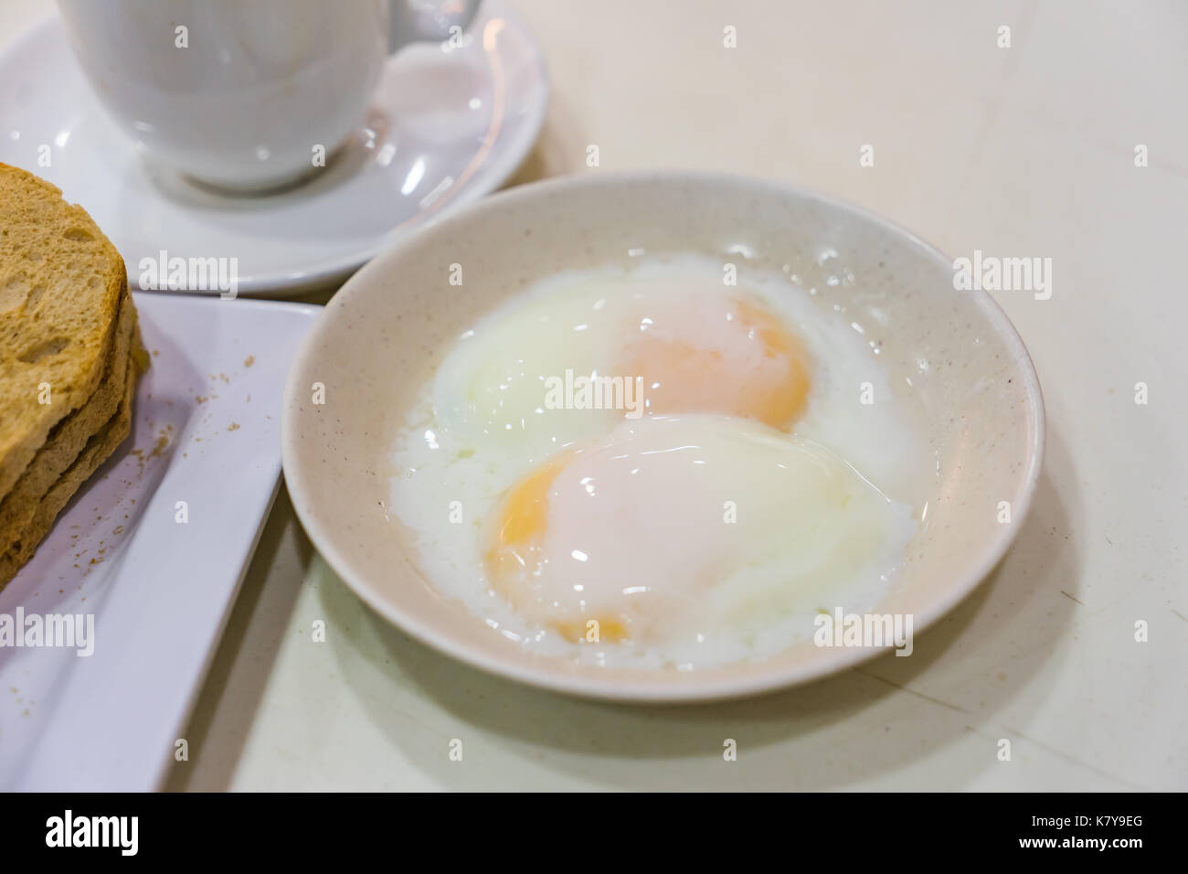 Mezza uova sode, Singapore tradizionale breakfast chiamato kaya toast, originale pane tostato con kaya un inceppamento del locale a base di uova, lo zucchero e il latte di cocco Foto Stock