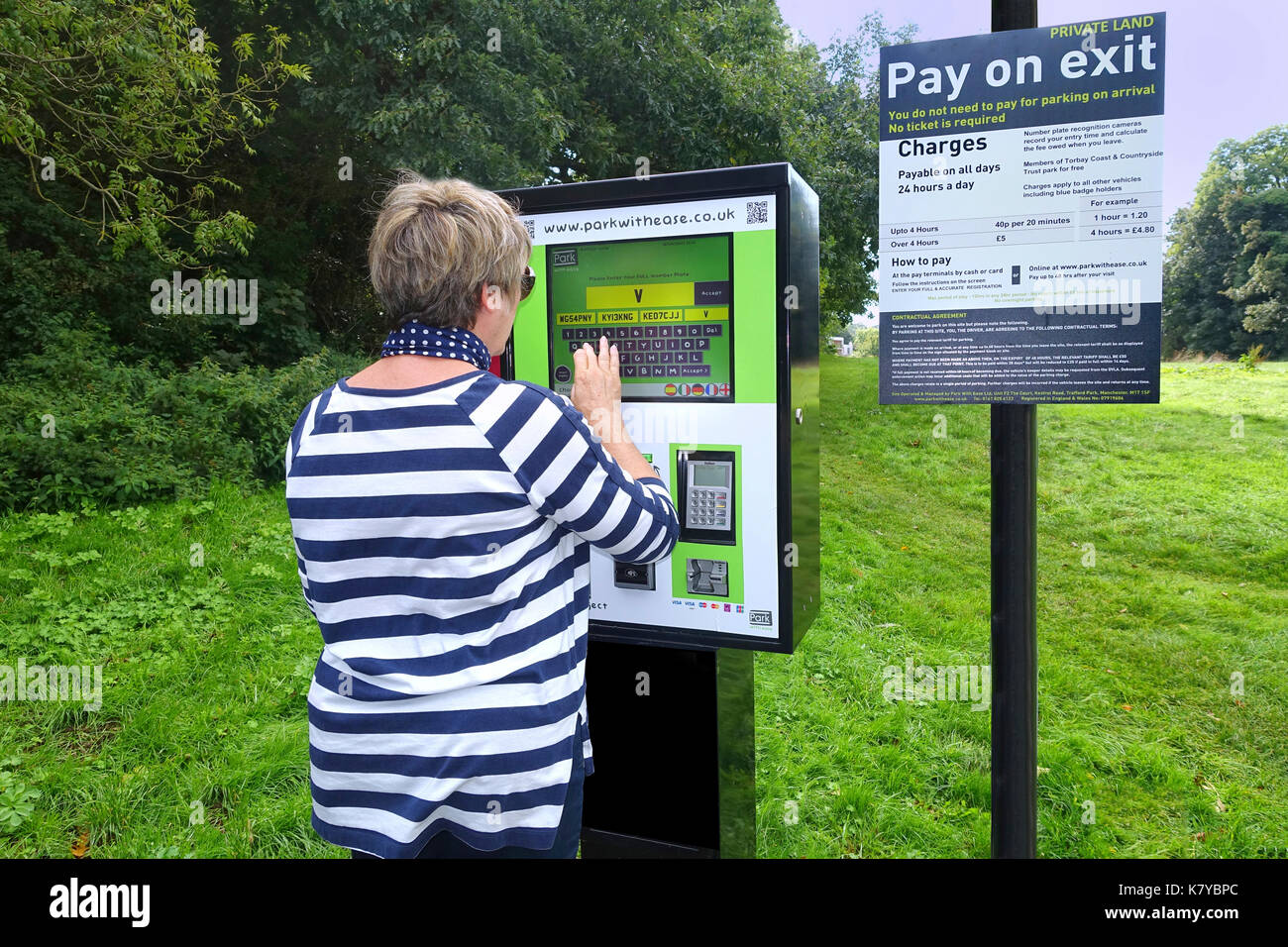 Donna utilizzando l'ultima grande touch-screen i biglietti per il parcheggio della macchina - torquay Foto Stock