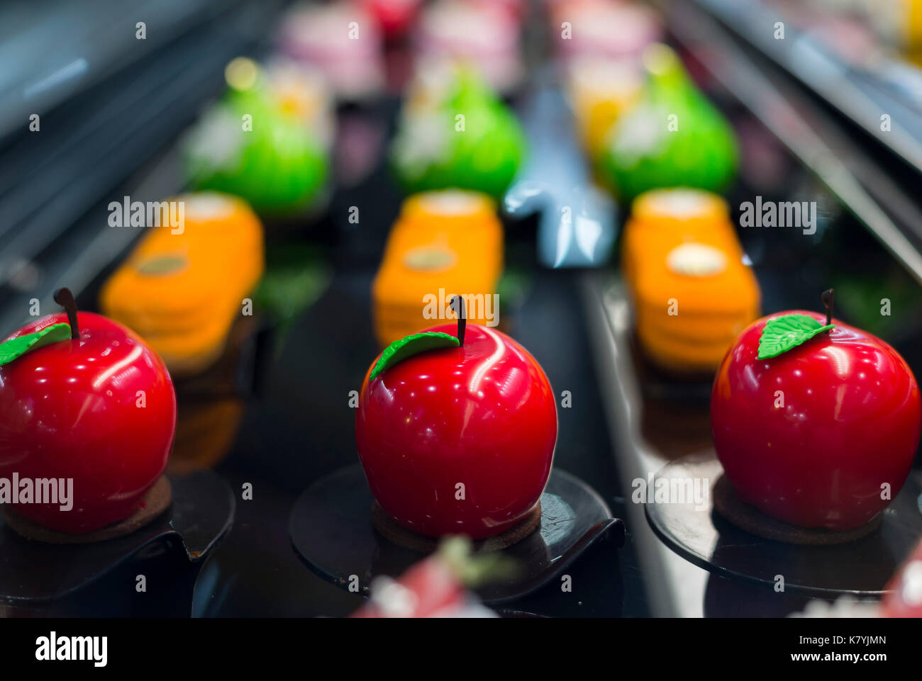 Un a forma di mela smalto specchio mousse in un frigorifero in un cafe'. Foto Stock