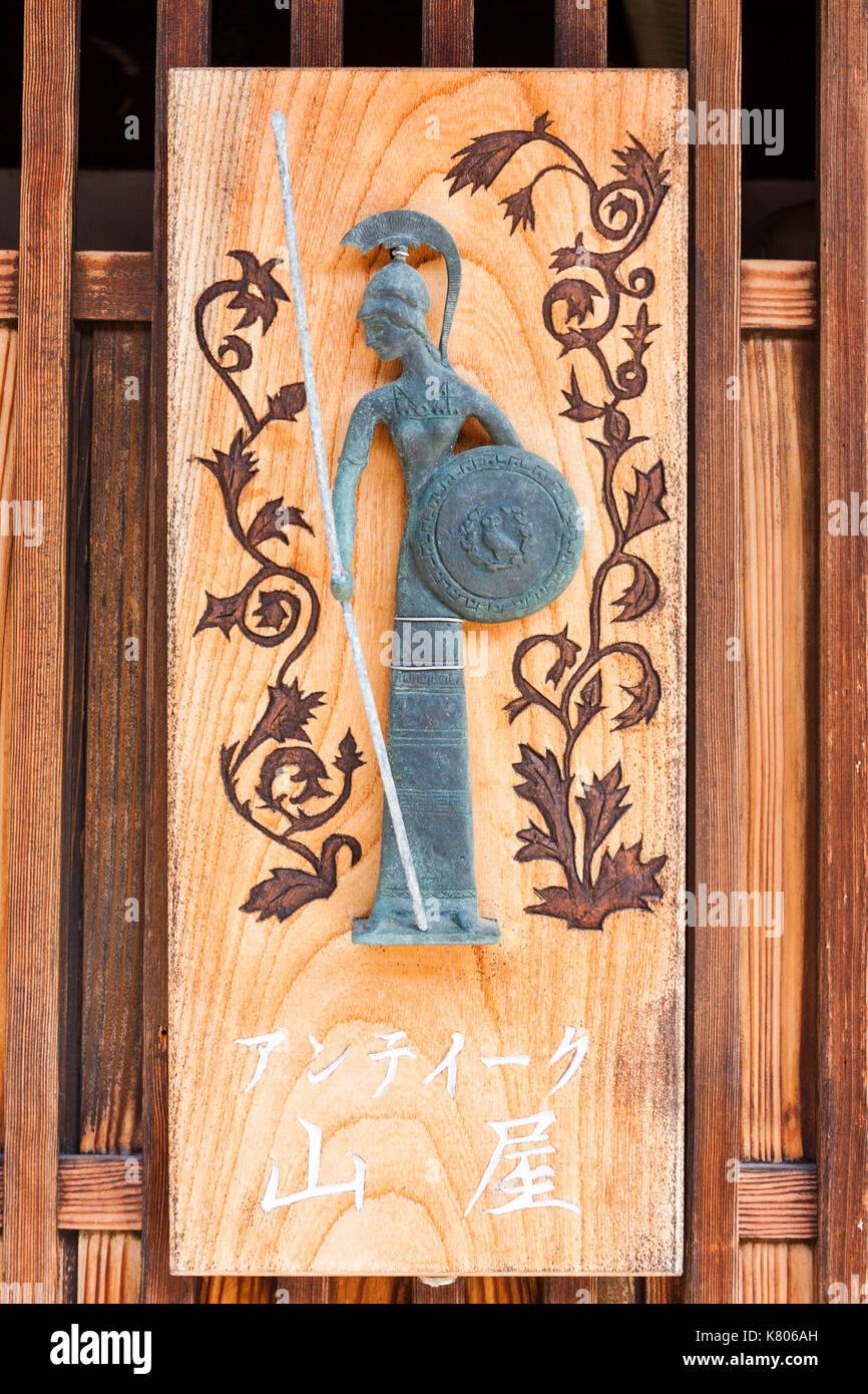 Giappone, Kanazawa. Segno al di fuori del periodo Edo giapponese tradizionale; store mostra profilo del guerriero spartano con scudo e lancia e casco. Foto Stock