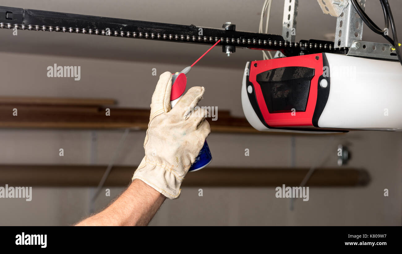 La manutenzione preventiva su un telecomando di apertura garage catena con un po' di olio Foto Stock