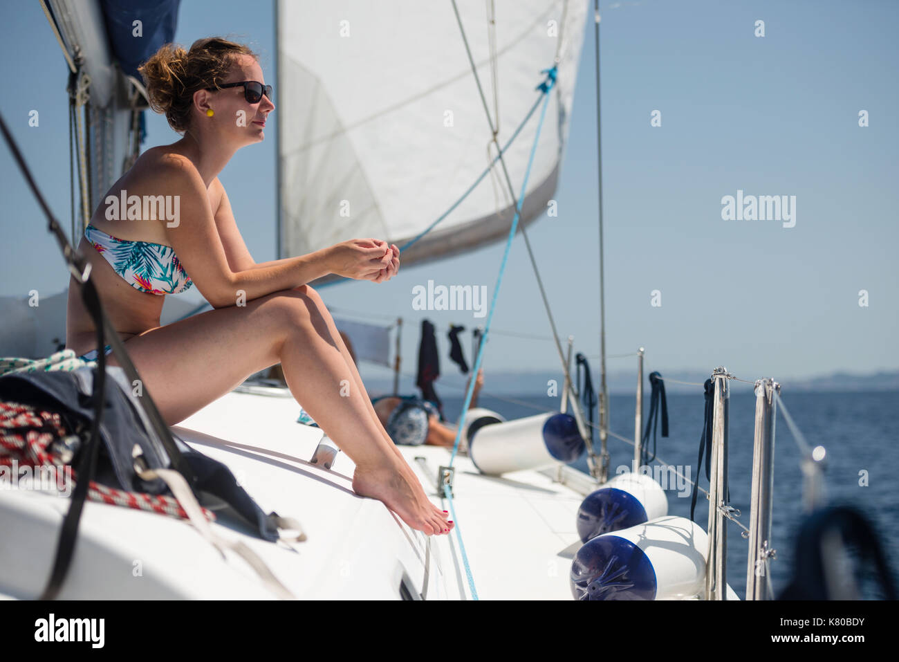 Giovane donna sul ponte dello yacht a vela godendo la vacanza Foto Stock