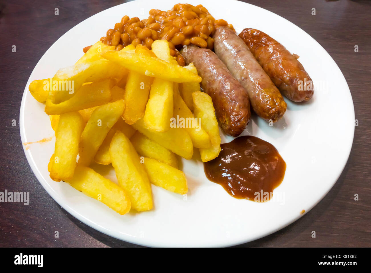 Un tradizionale poco costoso Café pasto, salsiccia, chips di fagioli e salsa bruna. Foto Stock