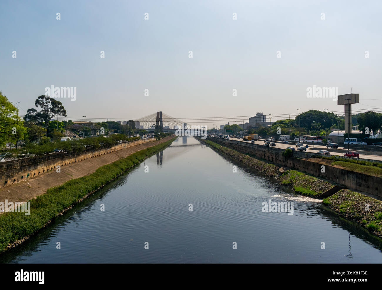 Paesaggio shot, fiume Tiete a San Paolo, Brasile, con il traffico a destra e ponte in lontananza Foto Stock