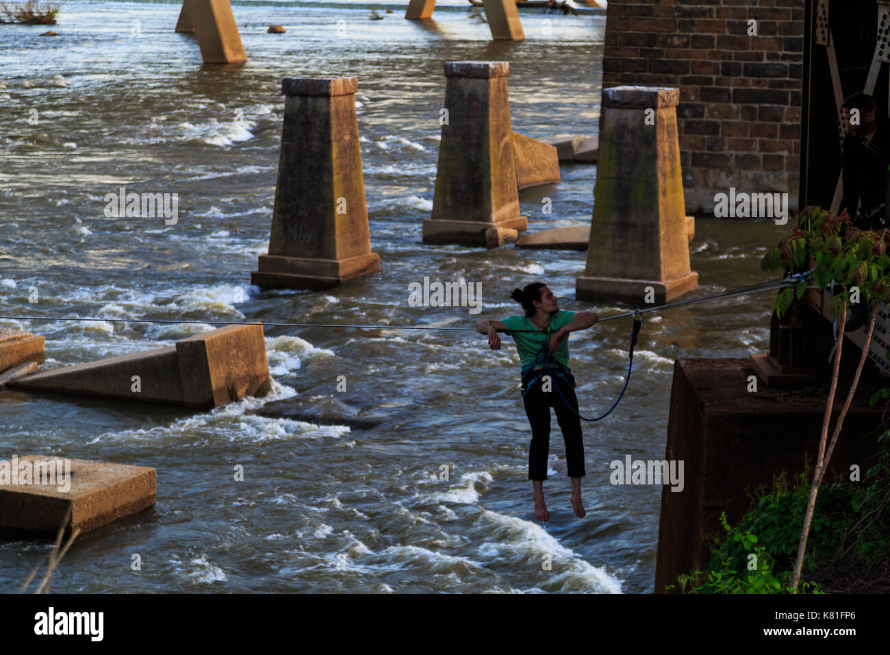 Ponti, tubazione, vista sul fiume, strutture storiche vicino al fiume james sul lato di richmond vicino isola marrone. persone che svolgono attività kayak, zi Foto Stock