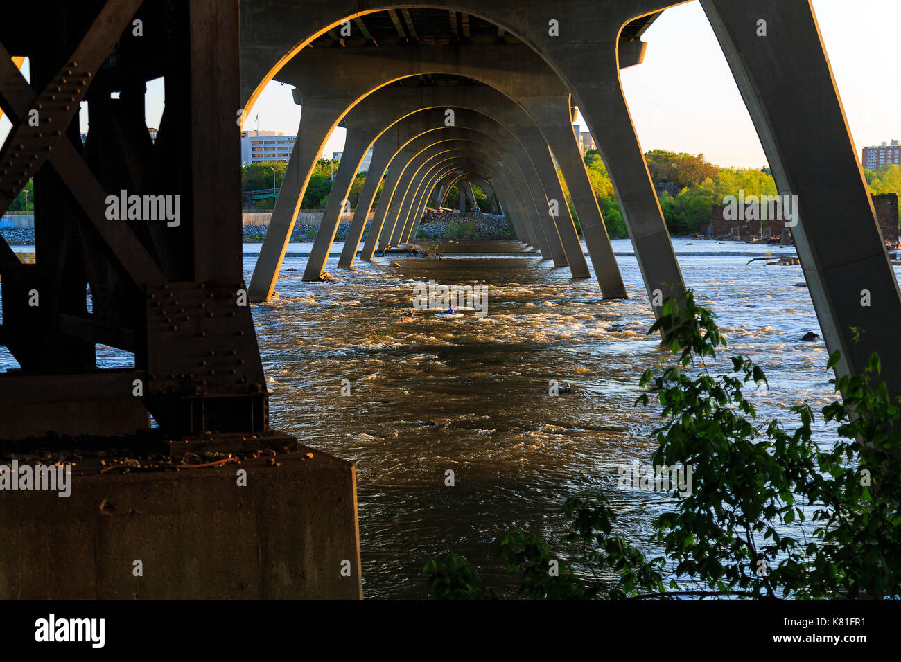 Ponti, tubazione, vista sul fiume, strutture storiche vicino al fiume james sul lato di richmond vicino isola marrone. persone che svolgono attività kayak, zi Foto Stock