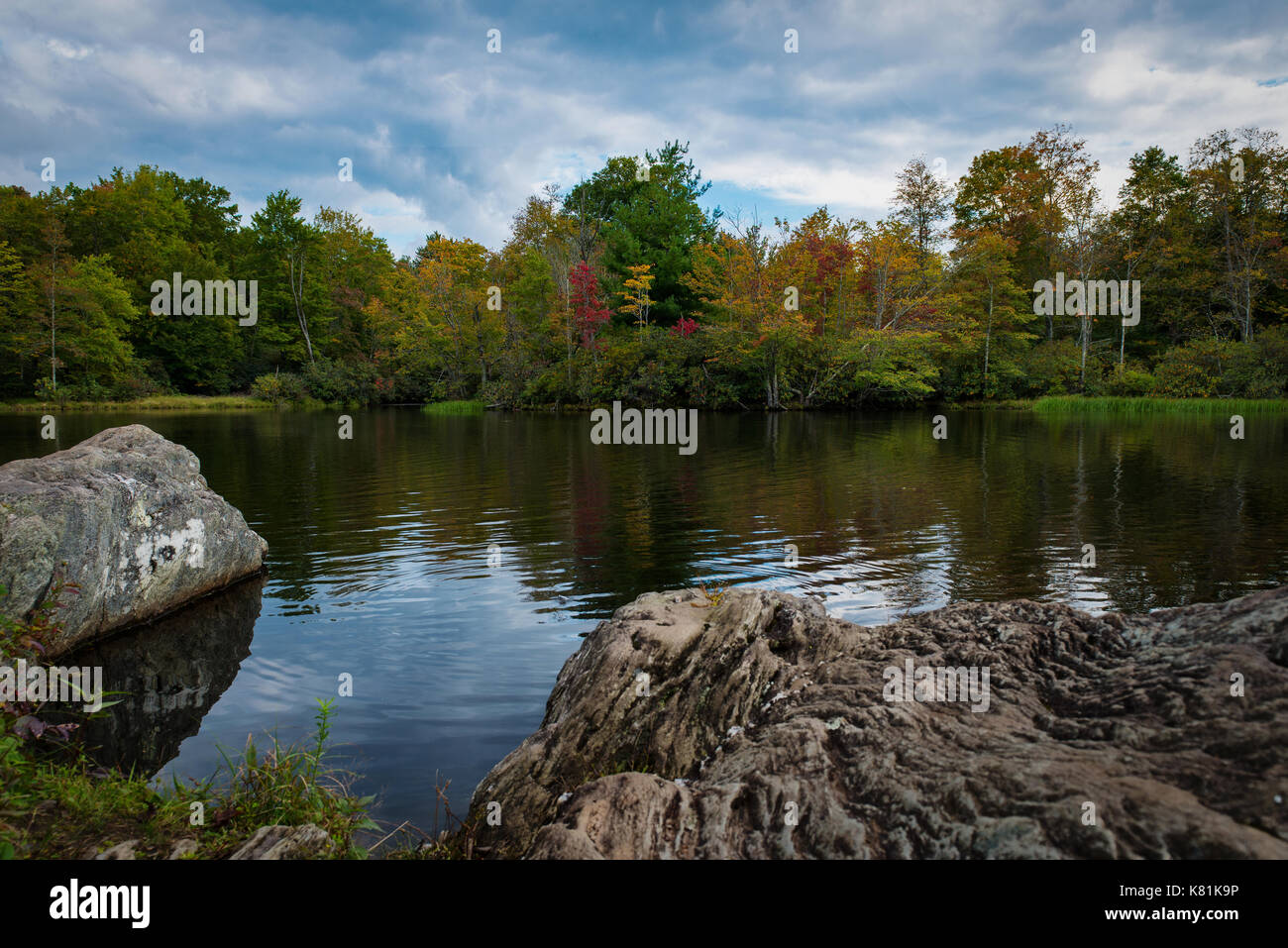 Prezzo lago - inizio di caduta colori montagna lago riflesso nell'acqua - grandi massi sommerso in acqua - rilassante e calmante acque vi invitano a nuotare Foto Stock