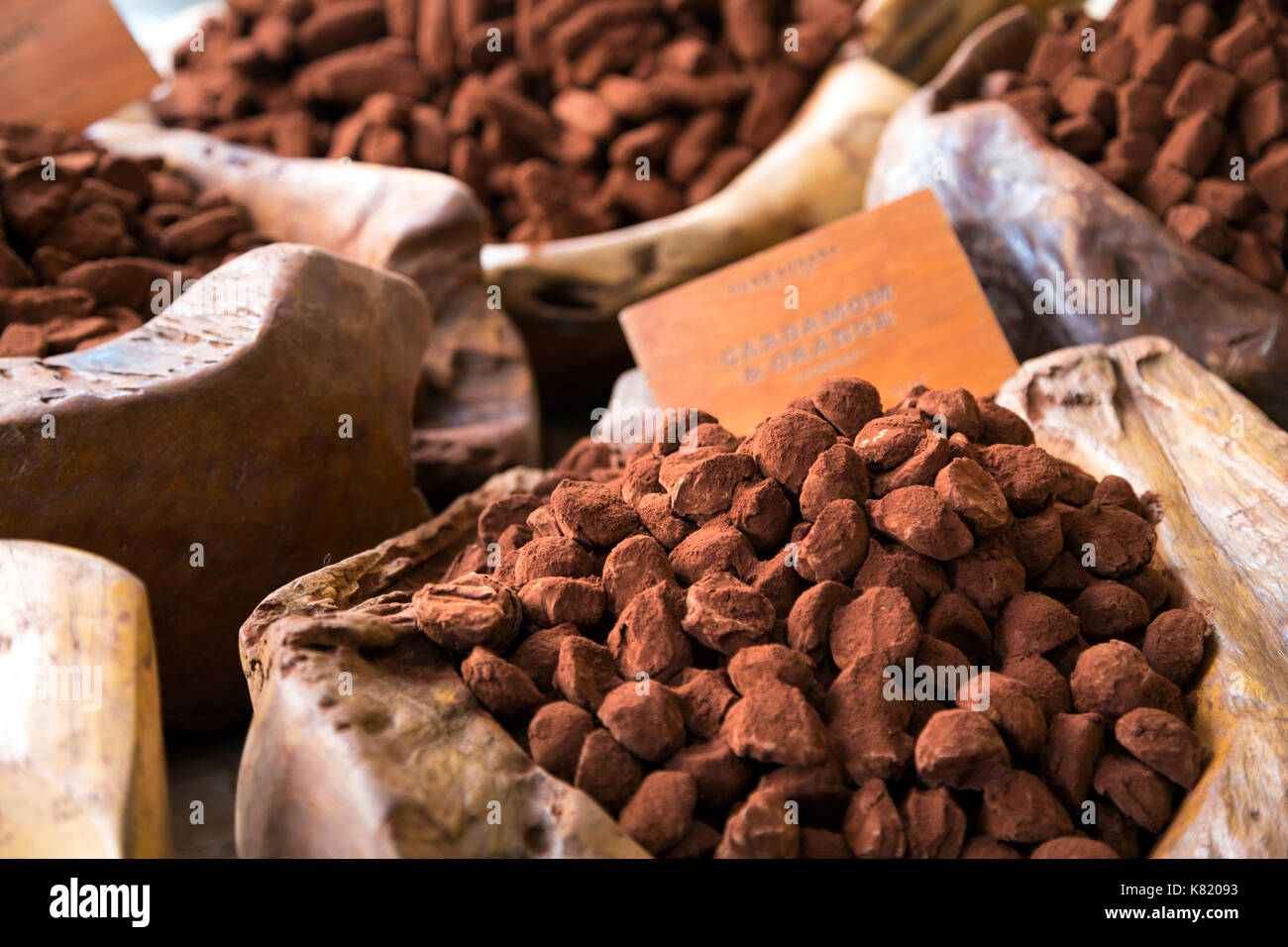 Spolverata di cacao tartufi sul display in ciotole di legno scuro (zuccheri cacao House, Londra, Regno Unito) Foto Stock