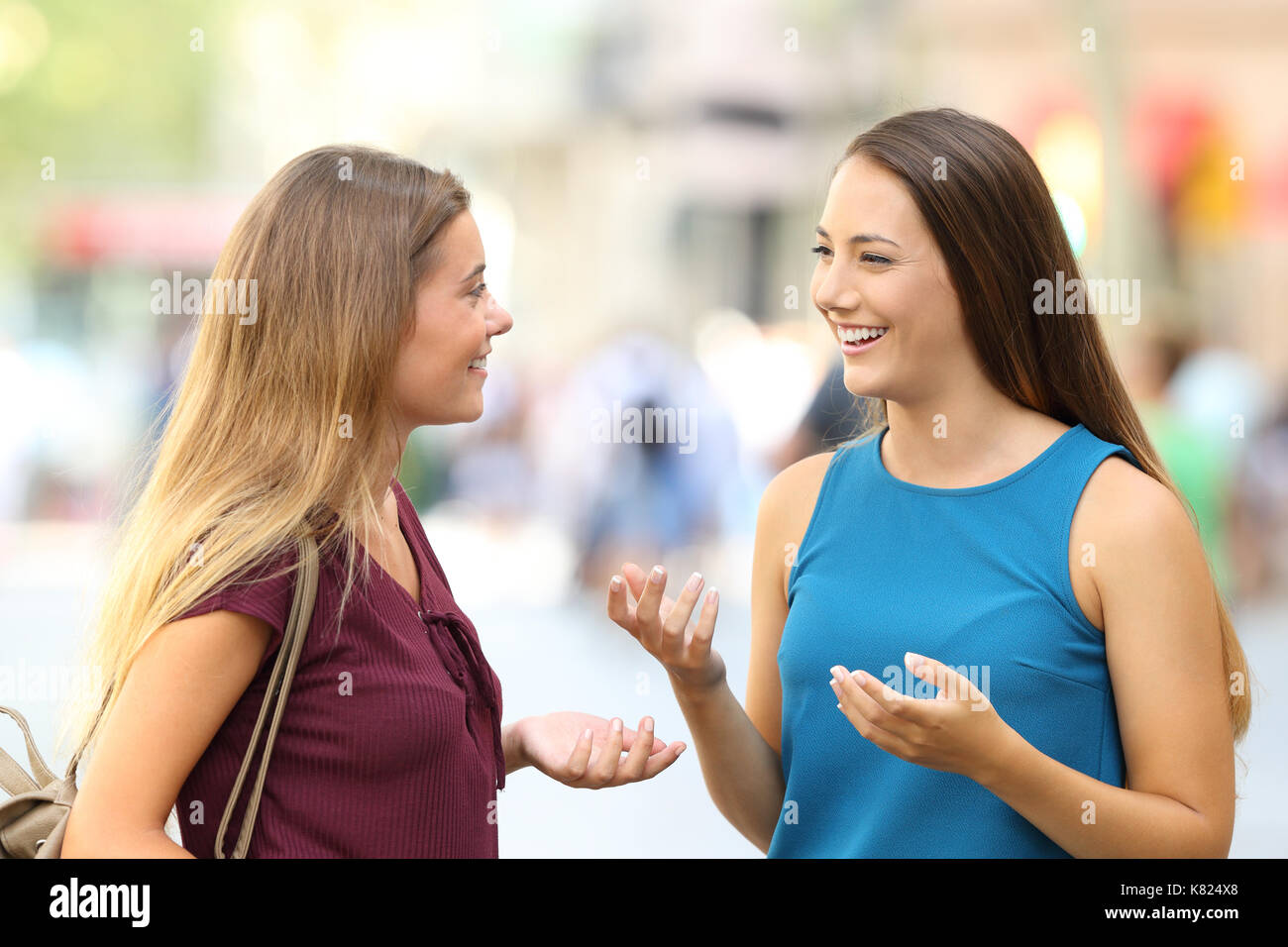 Due amici felici incontrare e parlare sulla strada Foto Stock
