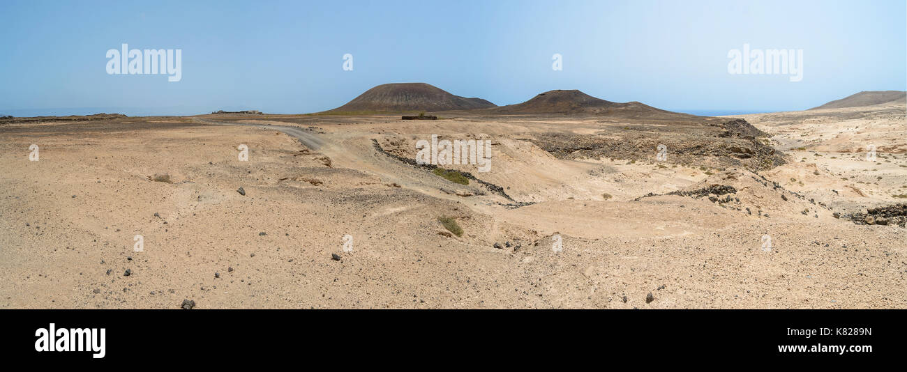 Dune di sabbia e rocce di Fuerteventura isola con vulcani sullo sfondo, Canarie Foto Stock