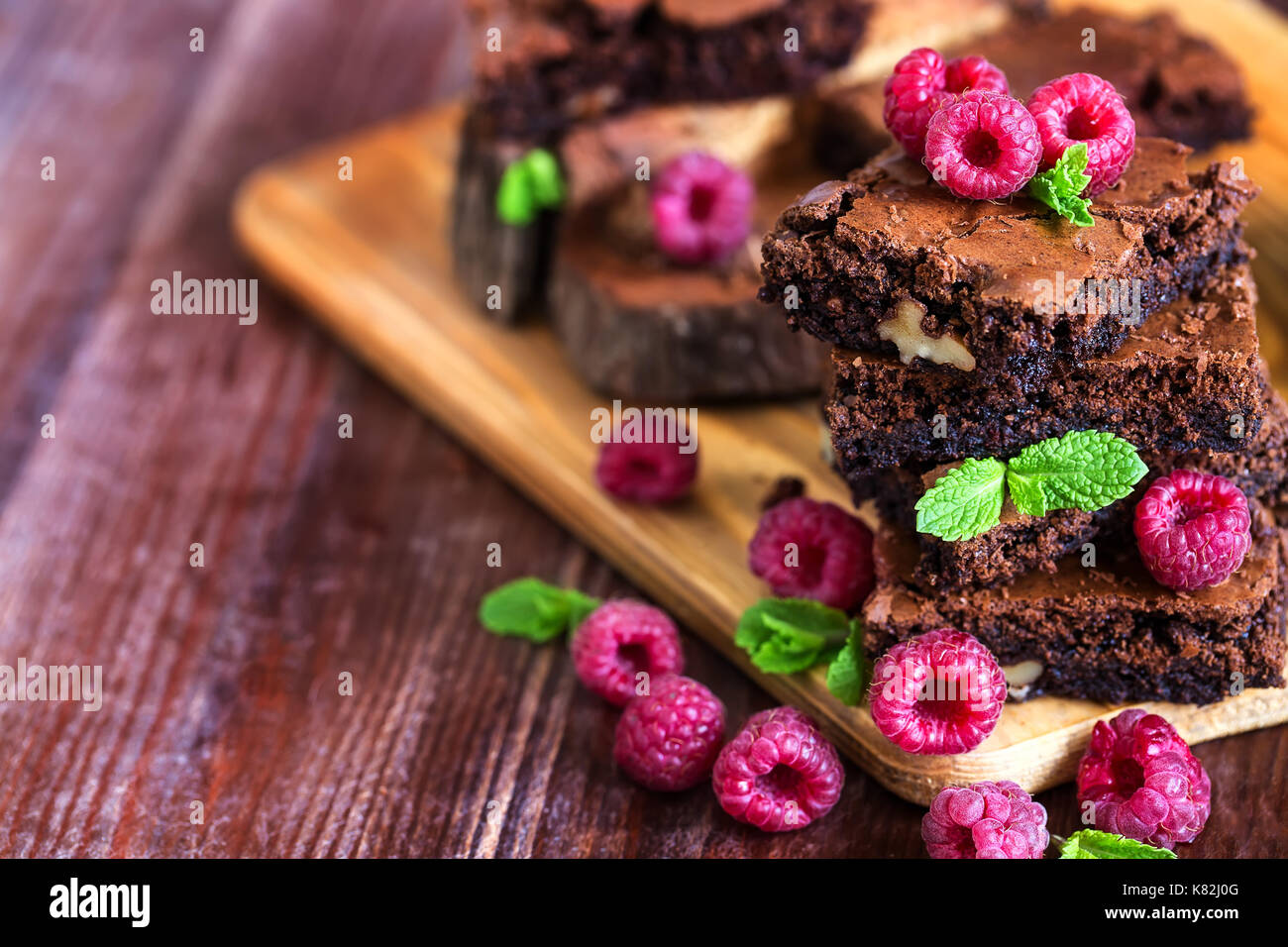 Brownie piazze decorate con lamponi freschi e le foglie di menta. copia di sfondo spazio. Foto Stock