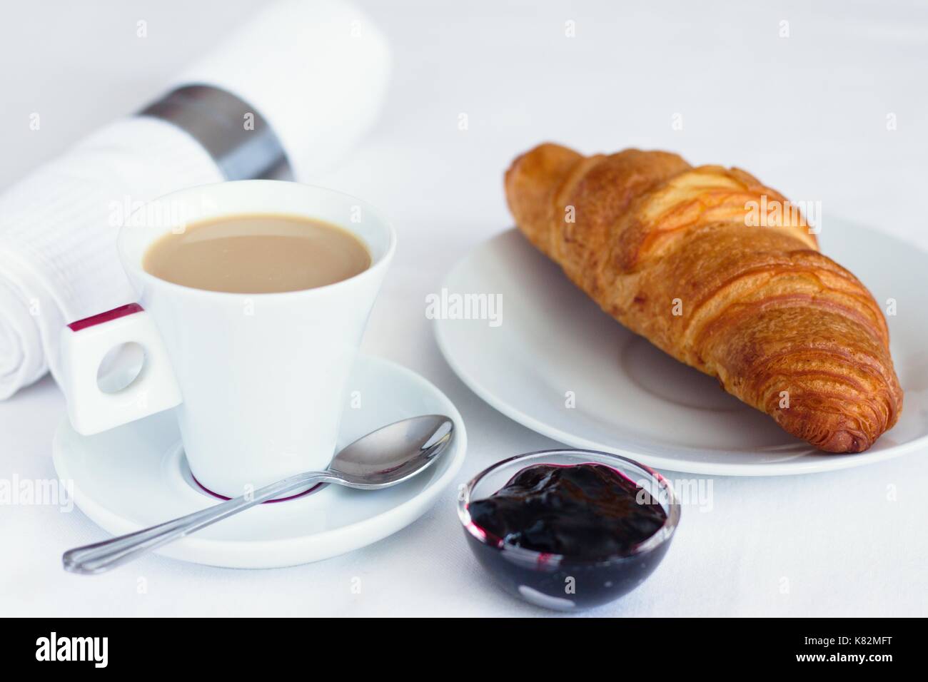 Caffè e croissant al burro e confettura di mirtilli Foto Stock