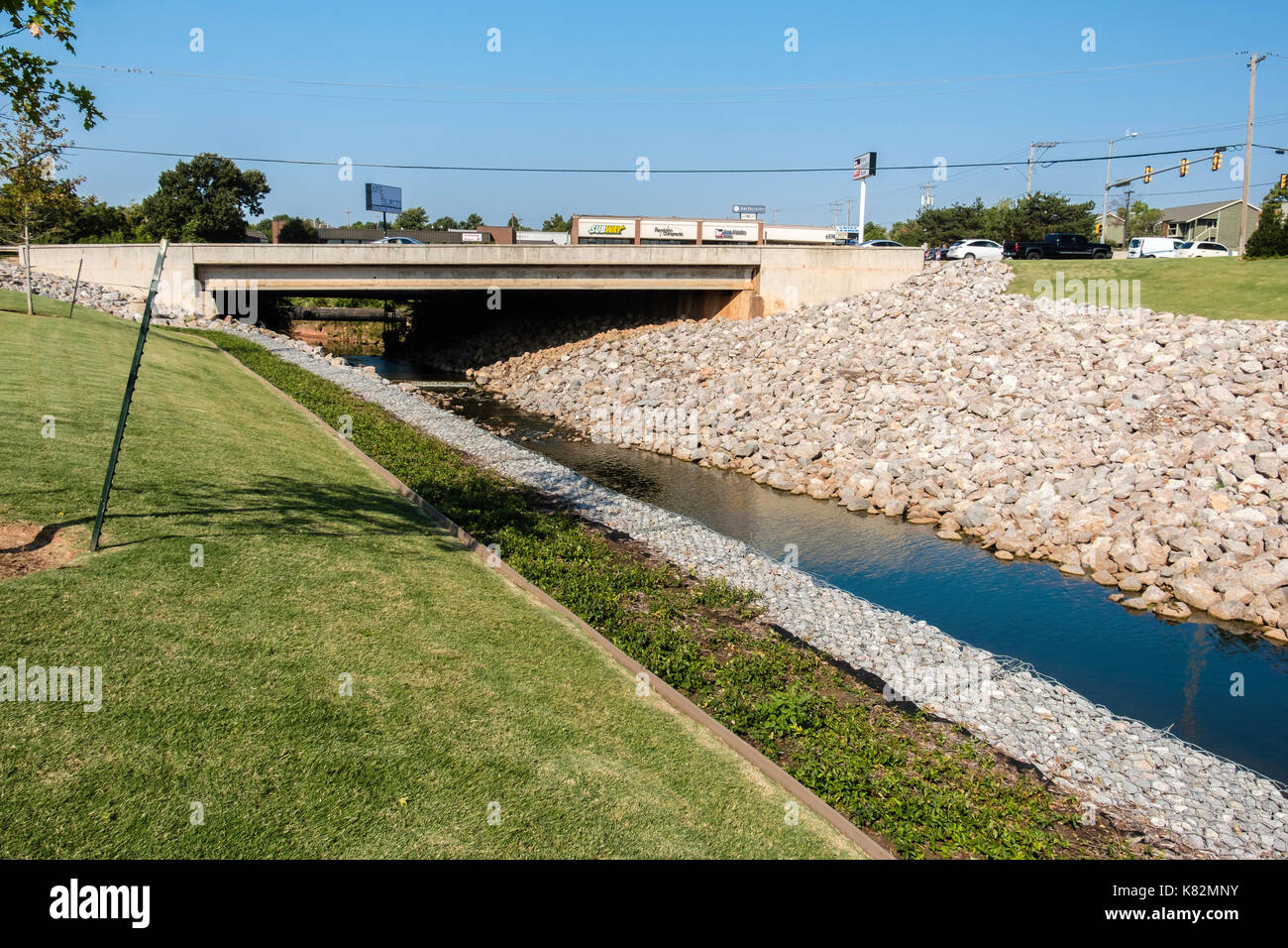 Rip-rap pietre di puntellamento di un canale di drenaggio sotto un ponte nella città di Oklahoma, Oklahoma, Stati Uniti d'America. Foto Stock
