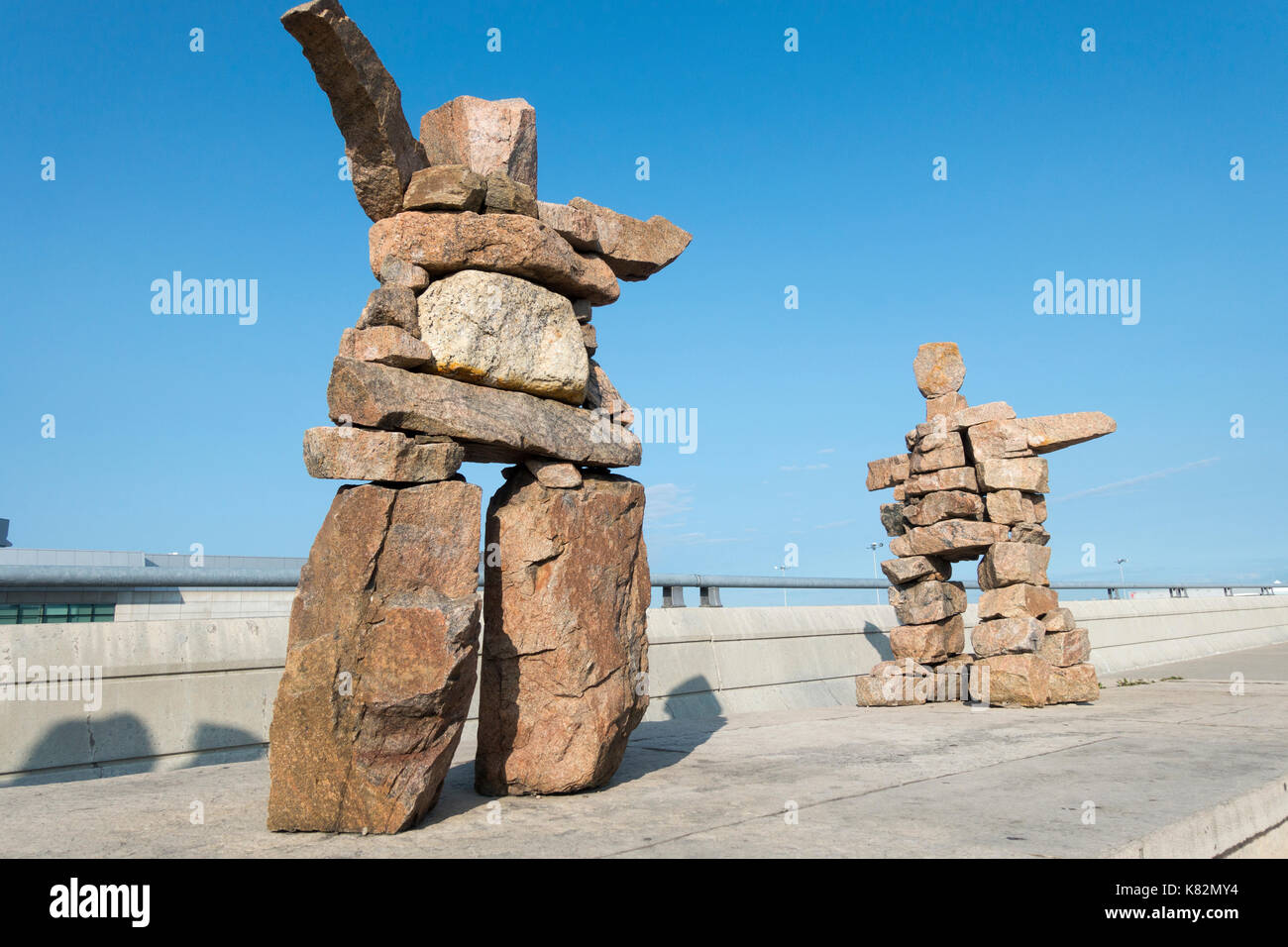 Due granito inukshuk sculture in aria pone di marshalling all'Aeroporto Pearson di Toronto Ontario Canada Foto Stock