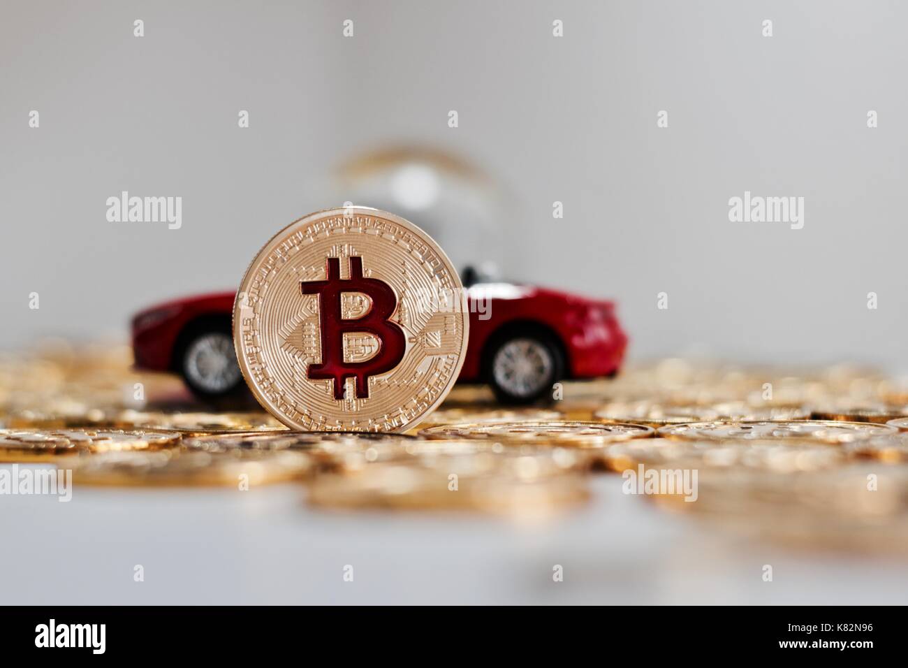 Valuta digitale metallo fisico bitcoin moneta vicino red auto di lusso. finanziare cryptocurrency concetto. Foto Stock