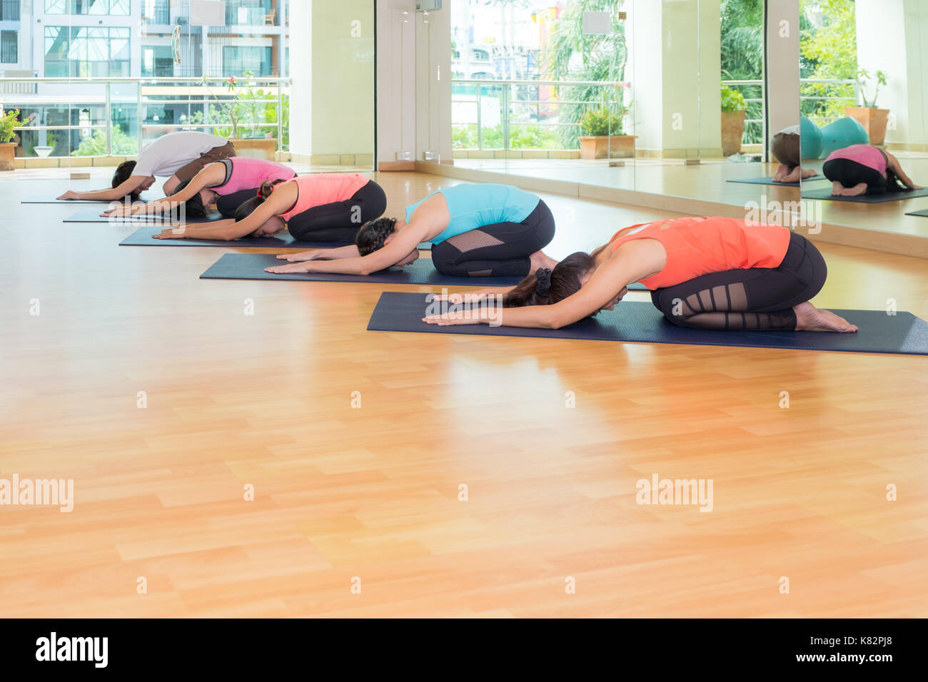 Gruppo di persone a praticare lo yoga per bambini pone in studio training room,balasana pone,benessere e uno stile di vita sano Foto Stock