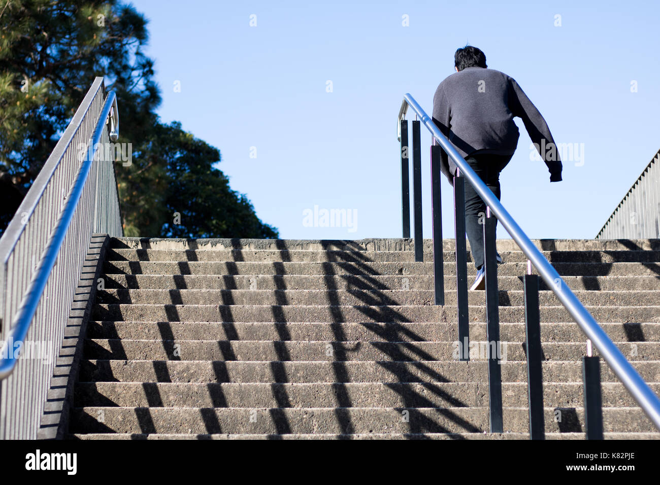 Vista posteriore della persona a salire le scale Foto Stock