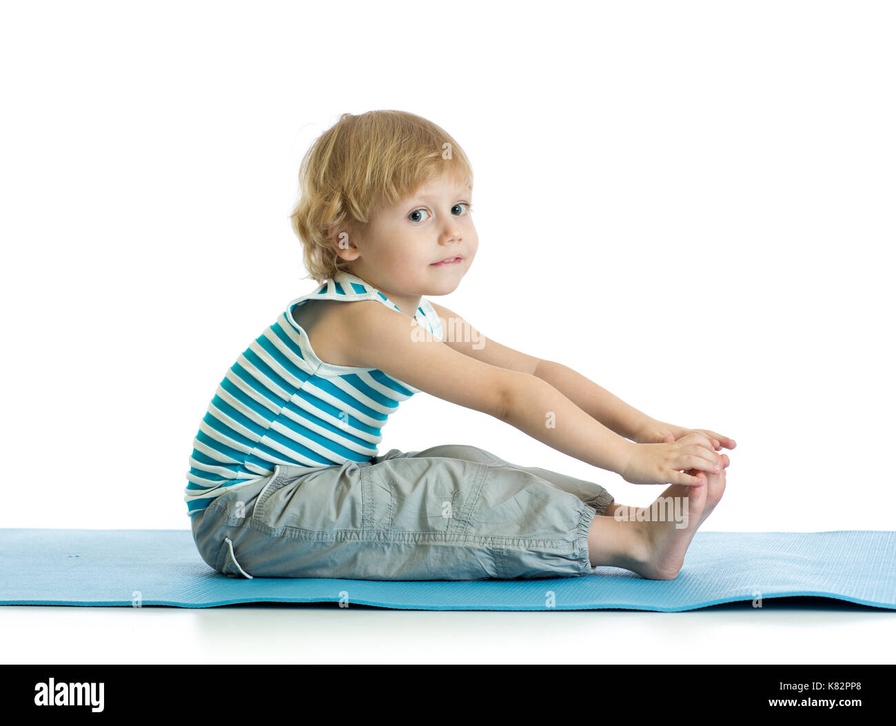 Ragazzo bambino la pratica dello yoga, stretching in esercizio di indossare abbigliamento sportivo. kid isolate su sfondo bianco Foto Stock