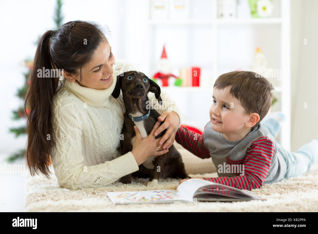 La famiglia felice si divertono con il nuovo cucciolo a Natale. Foto Stock