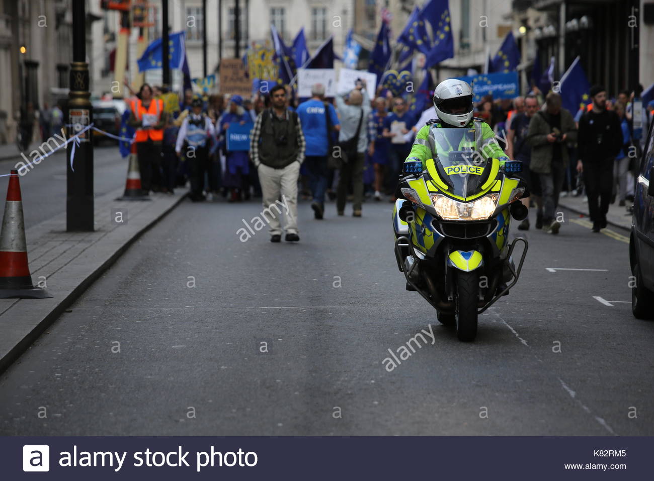 Un poliziotto su una moto conduce un anti-Brexit pro-UE rally attraverso le strade di Londra verso Westminster. Foto Stock