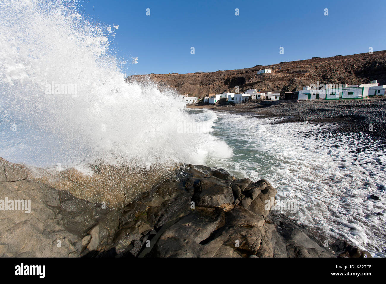 Spruzzi d'onda su una roccia sulla spiaggia di puertito de los Molinos a Fuerteventura Foto Stock