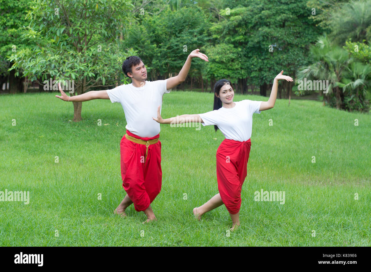 Asian giovane ragazzo e ragazze imparare danza thailandese. La danza classica in maglia bianca rosso perizoma, dimostrare la danza nel giardino Foto Stock