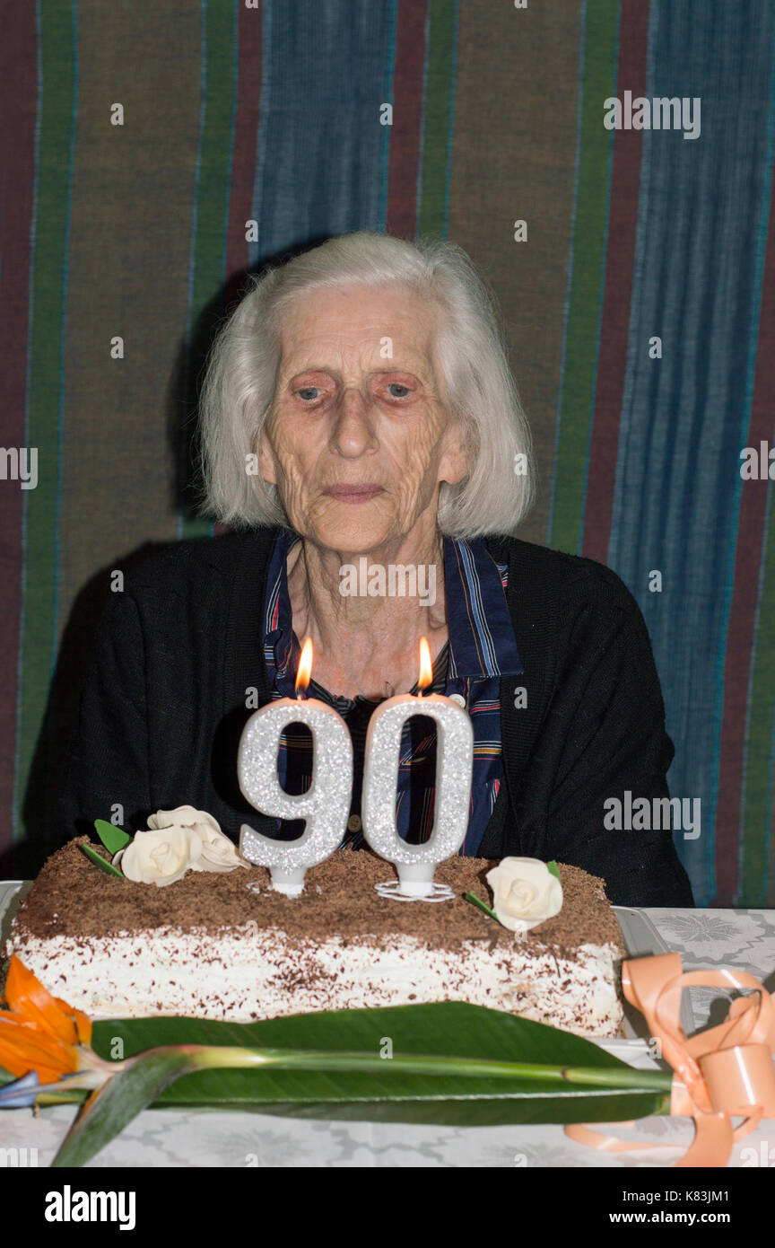 Nonna celebra il suo novantesimo compleanno e soffiando le candele Foto Stock