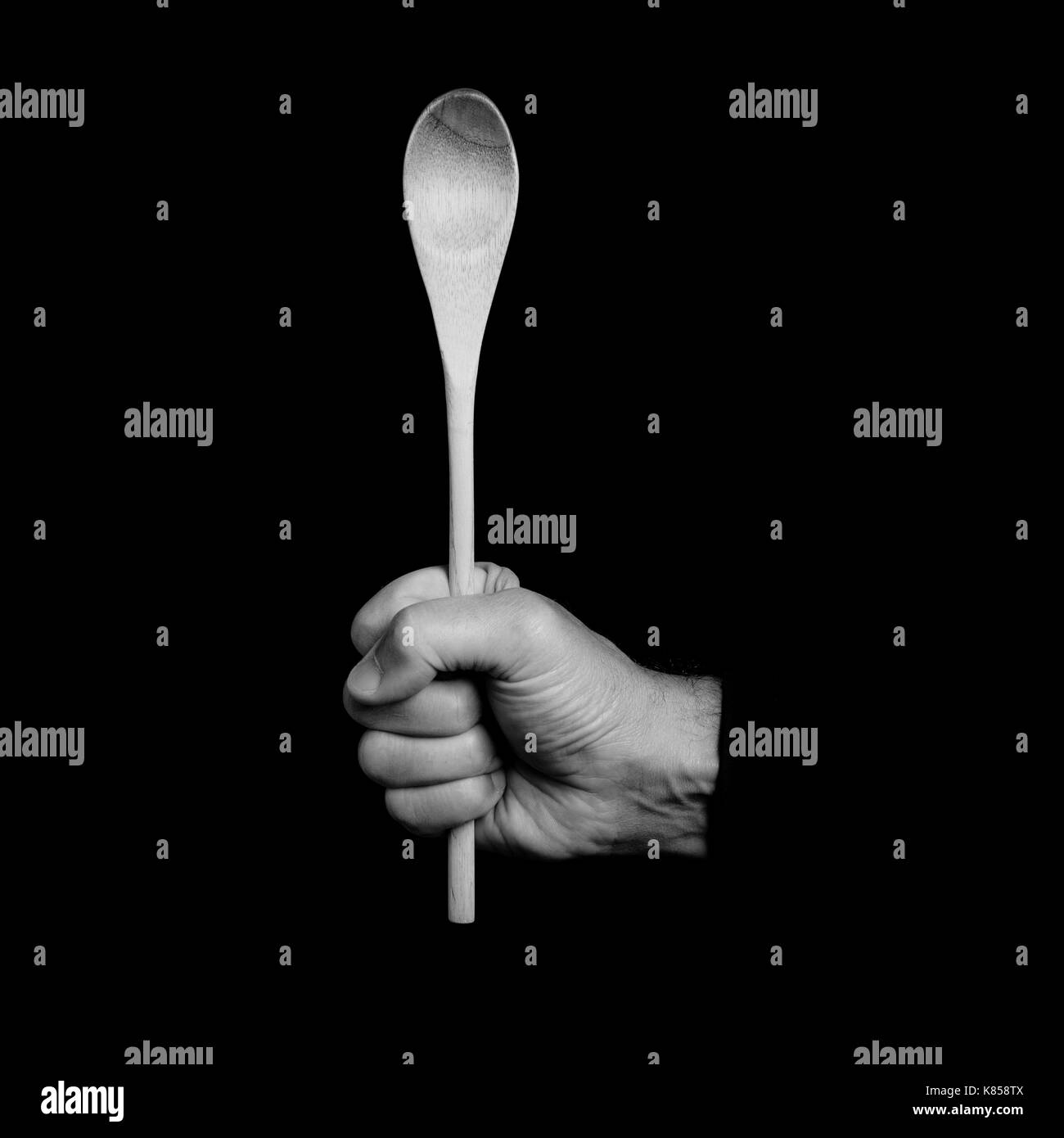 Il cucchiaio di legno - utensili da cucina in una mano d'uomo - foto in bianco e nero Foto Stock