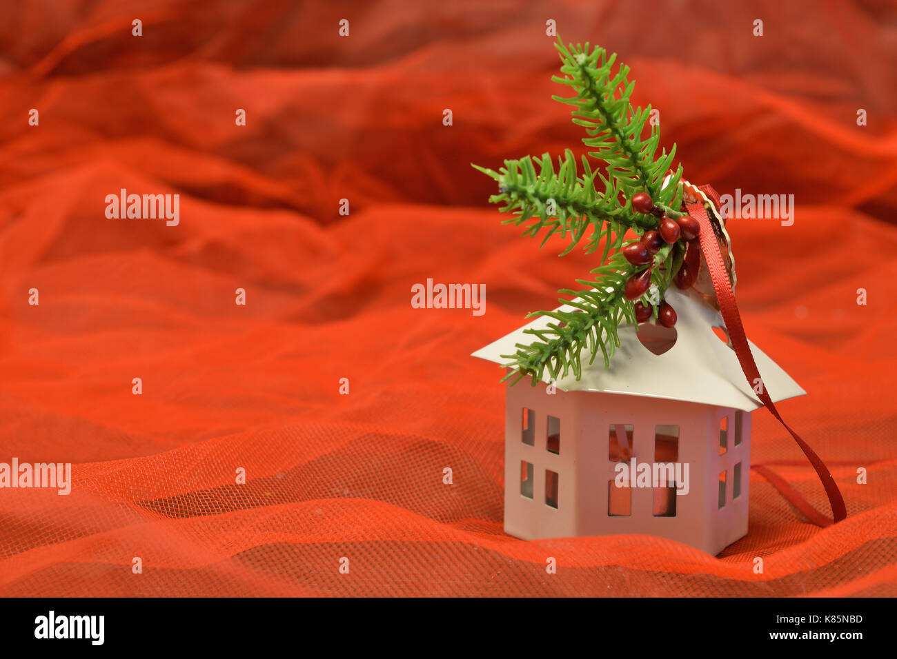 Piccola casa bianca lanterna sagomata su sfondo rosso Foto Stock