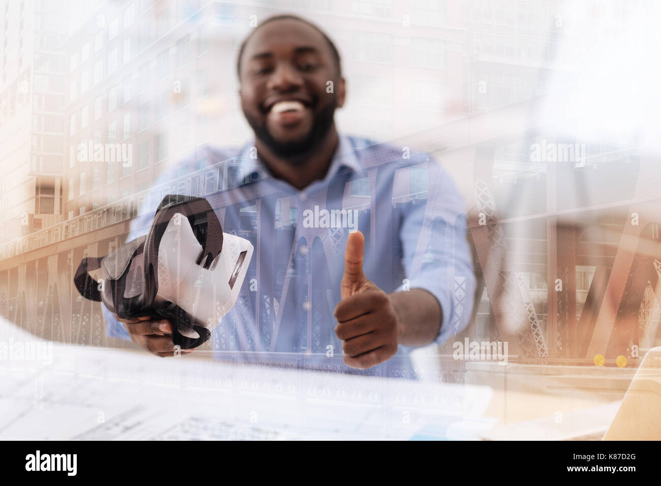 Soddisfatto African American mantenendo la maschera virtuale in mano Foto Stock