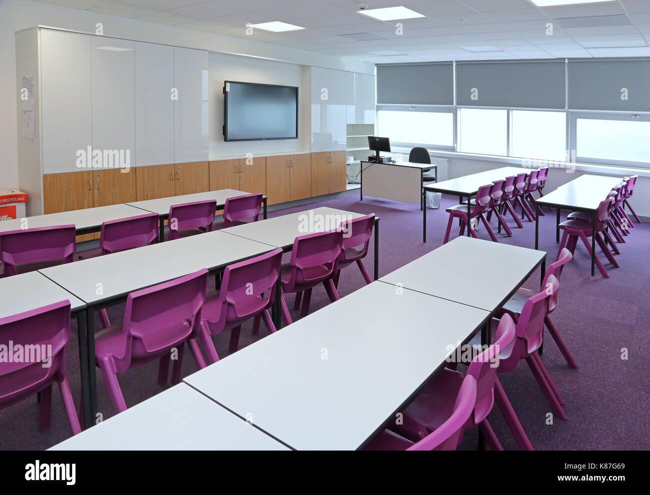 Una moderna classe in una nuova scuola secondaria londinese. Mostra il layout tradizionale con scrivanie di fronte a un grande computer monitor.vuoto, nessun alunni. Foto Stock