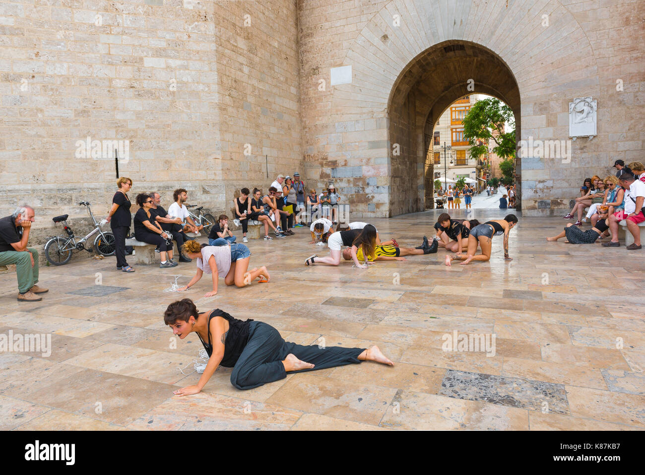Street performance in Spagna, in un gruppo di studenti di eseguire un avant garde dramma all'ingresso della Porta de Serrans a Valencia in Spagna. Foto Stock