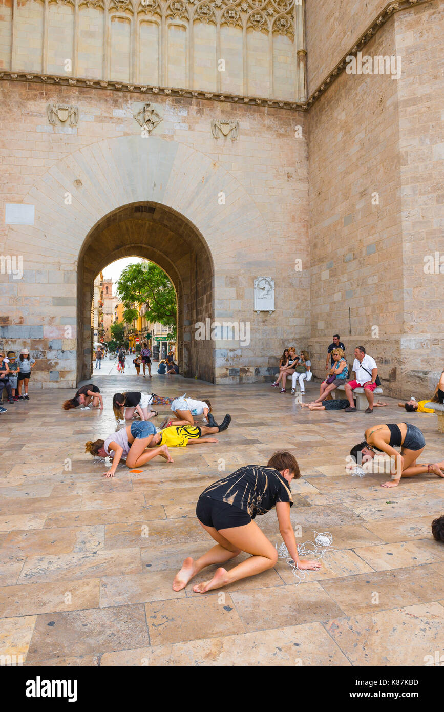 Street performance in Spagna, in un gruppo di studenti di eseguire un avant garde dramma all'ingresso della Porta de Serrans a Valencia in Spagna. Foto Stock
