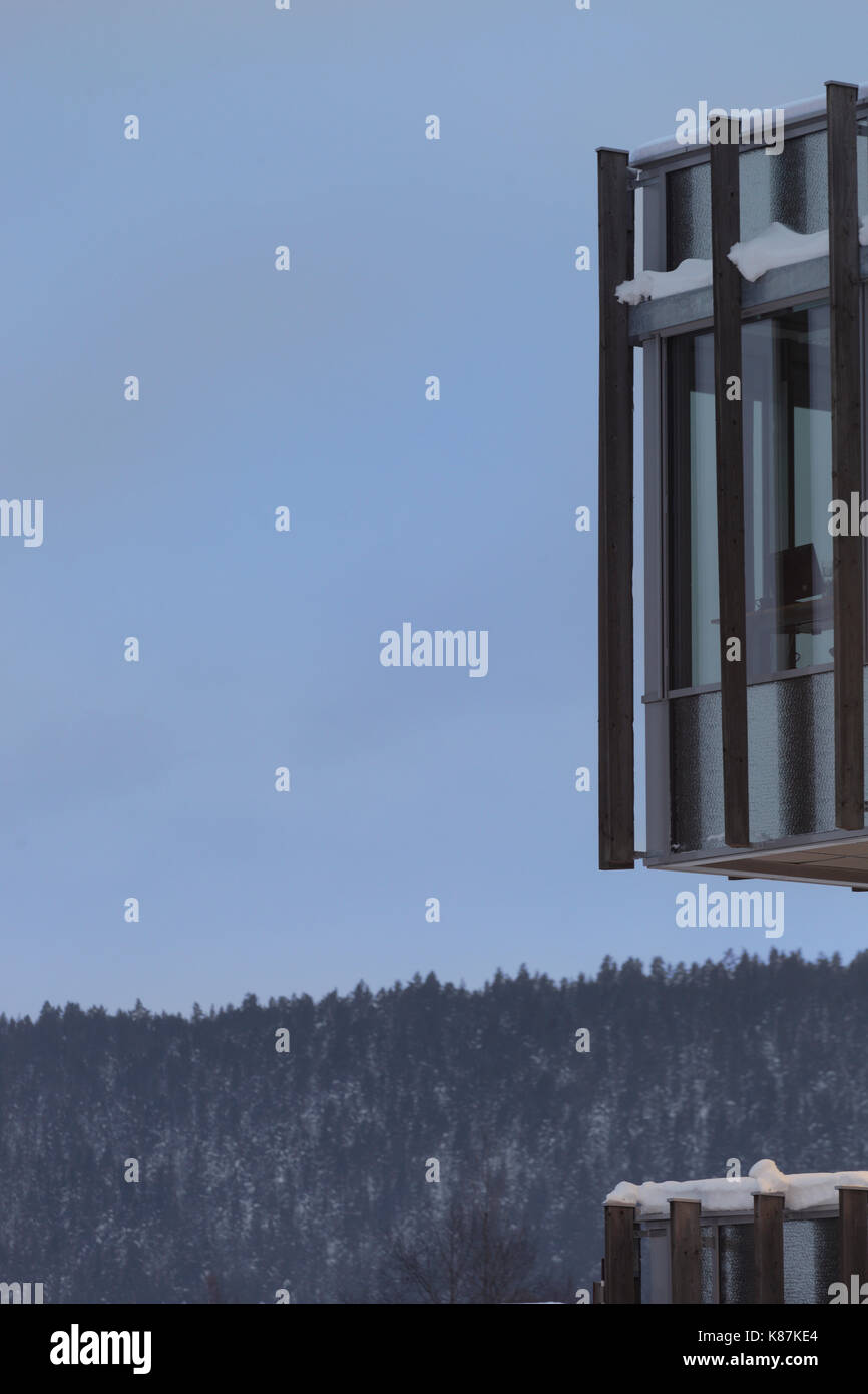 Particolare della facciata con alette di legname e colline boscose al di là, su terreni innevati sera d'inverno. Krona Knowledge & Centro Culturale, Kongsberg, Norvegia. Architetto: Foto Stock