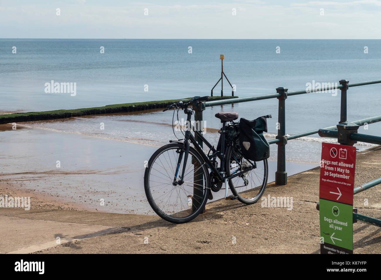 Una bicicletta sulle ringhiere accanto al mare a Sidmouth, nel Devon, Inghilterra Foto Stock