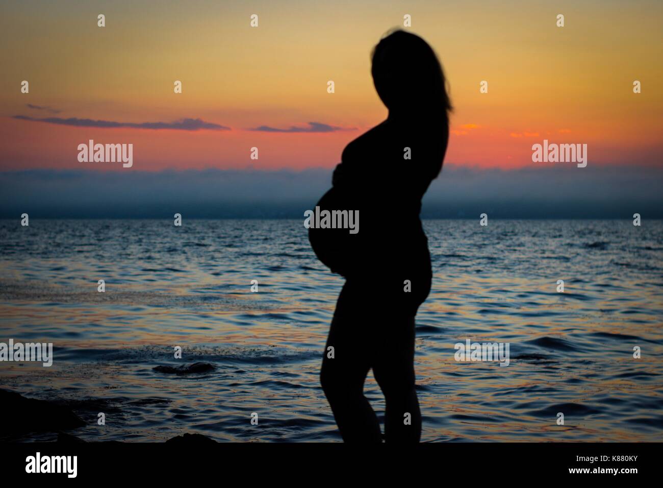 Maternità silhouette al tramonto Foto Stock
