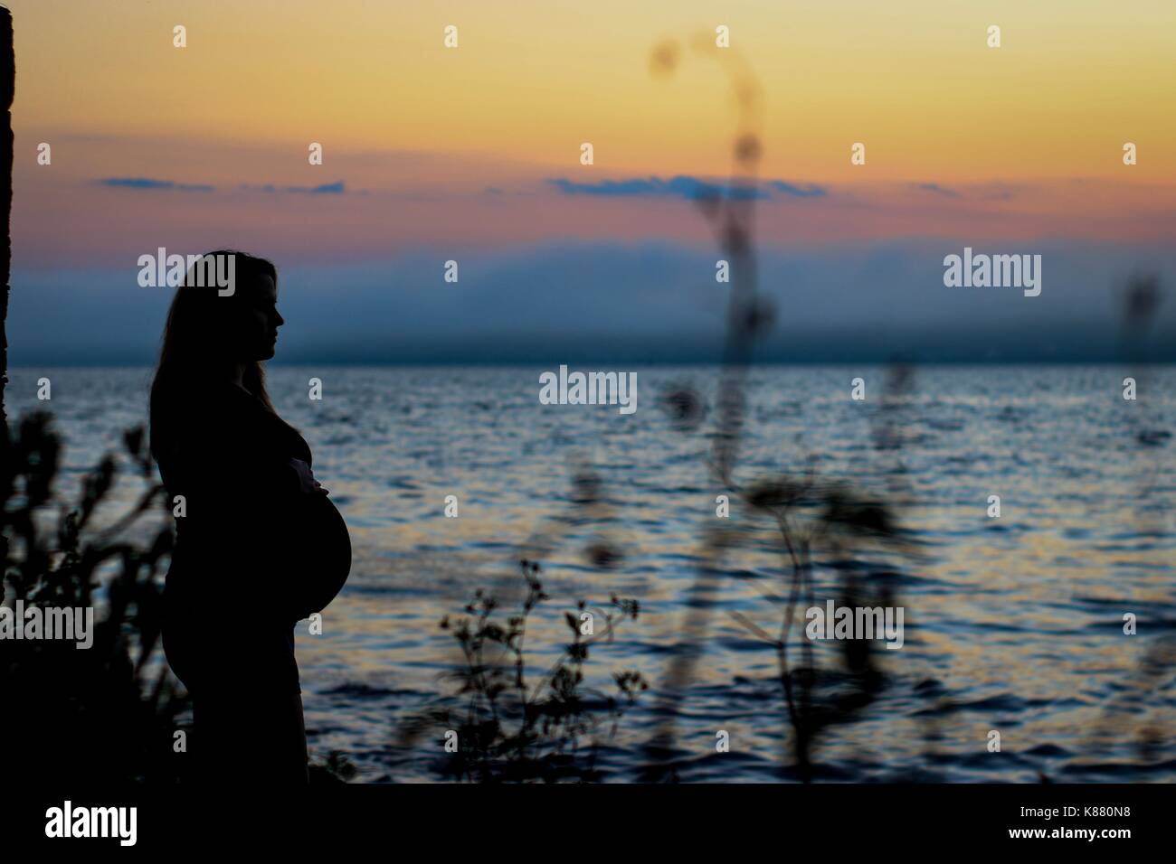 Maternità silhouette al tramonto Foto Stock