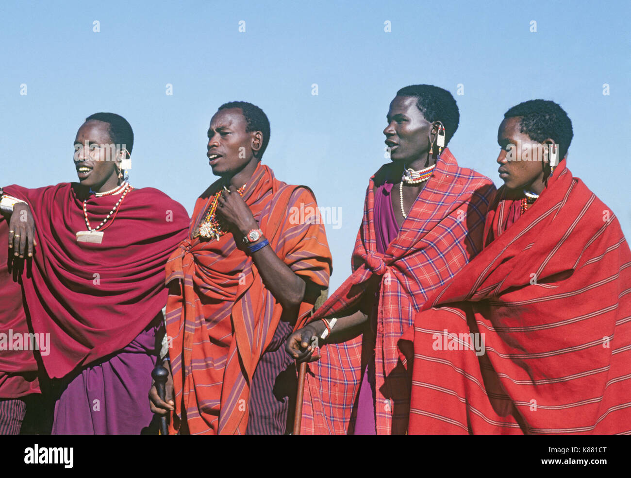 Un piccolo gruppo di Masaz uomini adulti parlare di bestiame in un piccolo e remoto villaggio Masai sul bordo del cratere di Ngorongoro in Tanzania Africa orientale Foto Stock