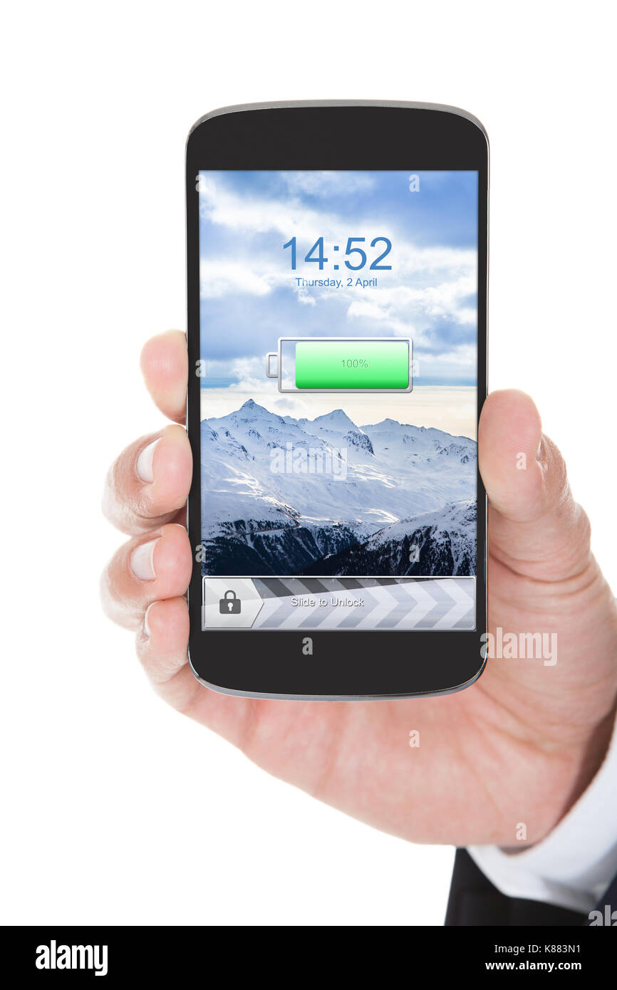 Mano che tiene il telefono cellulare con batteria carica su sfondo bianco Foto Stock