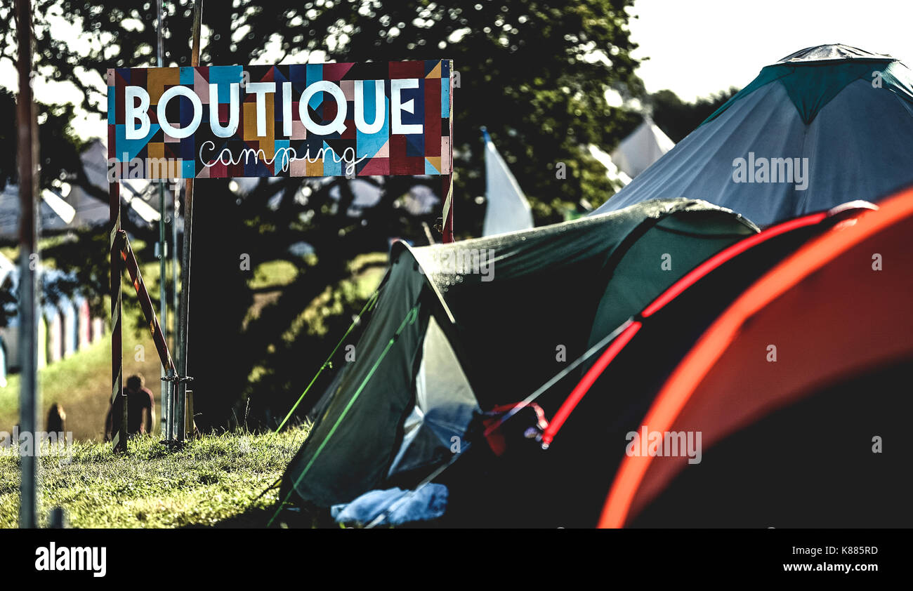 Tende sul prato in un area camping presso un outdoor music festival in estate. lettura del segno campeggio boutique. glamping. Foto Stock