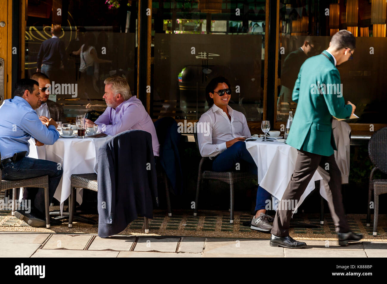 Un gruppo di ben vestito uomini seduti fuori Franco's Restaurant, Jermyn Street, Mayfair, London, Regno Unito Foto Stock