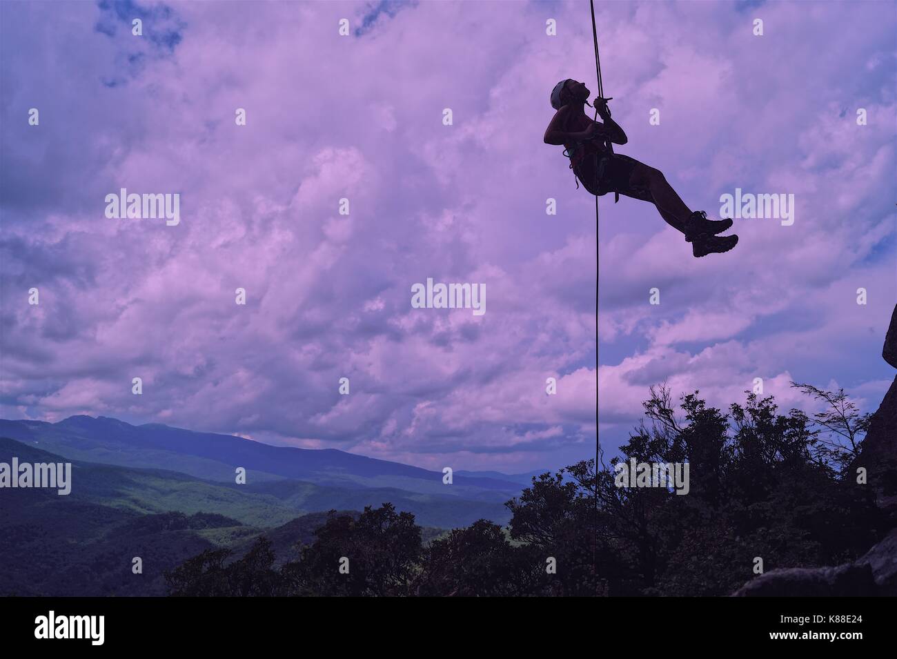 Persona appesi ad una fune su una scogliera Foto Stock