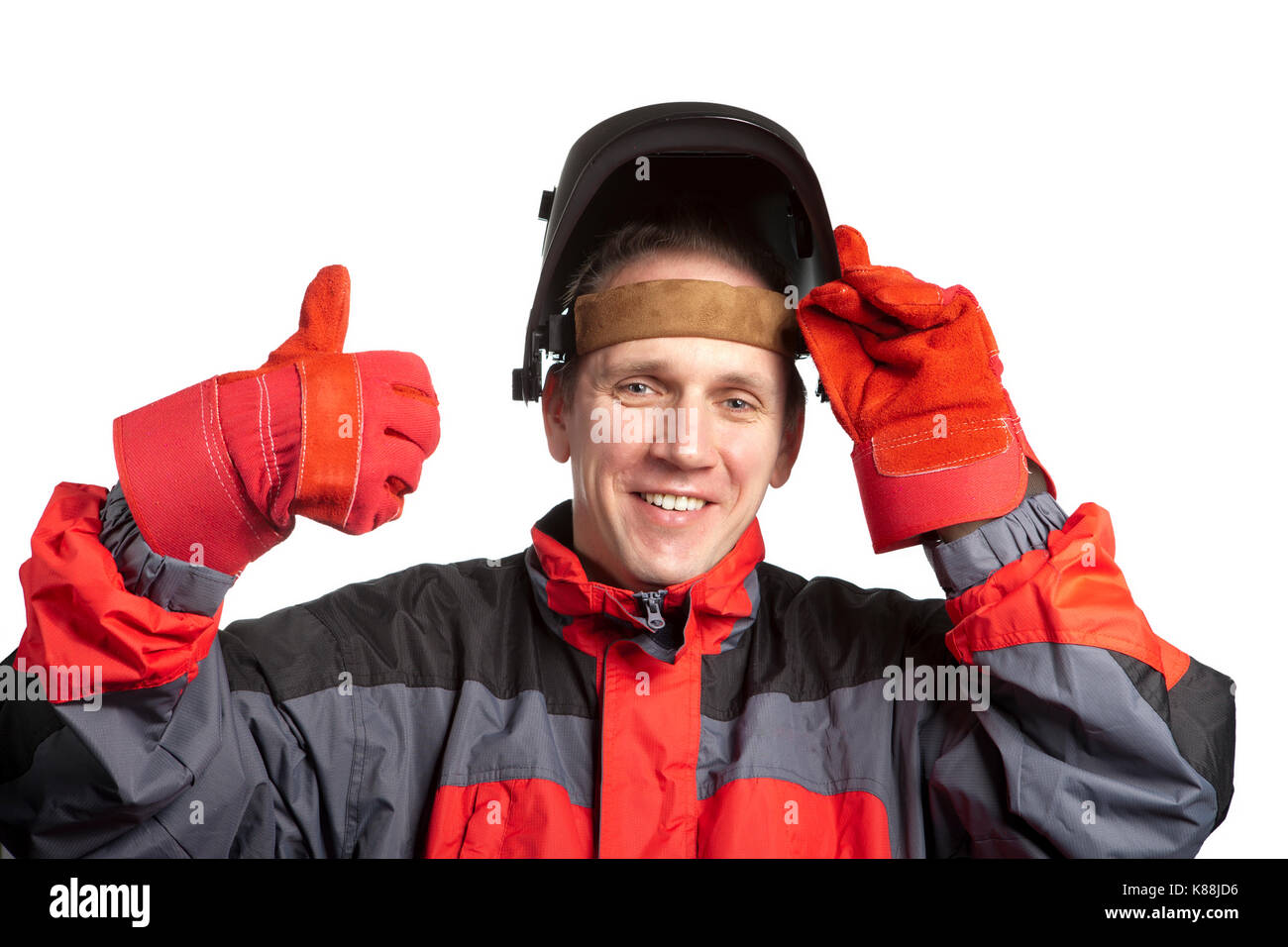 L'uomo in abiti da lavoro mette su una maschera del saldatore Foto Stock